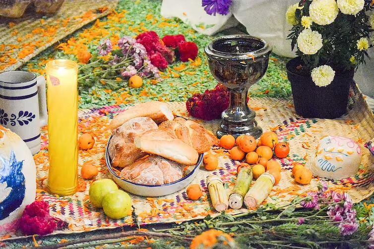 Pan de muerto y otras ofrendas en un altar de muertos. JMndz / Wikimedia Commons, CC BY-SA